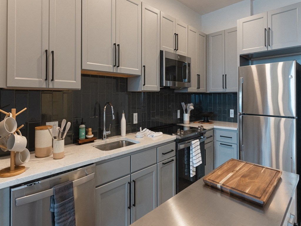 a kitchen with white cabinets and stainless steel appliances